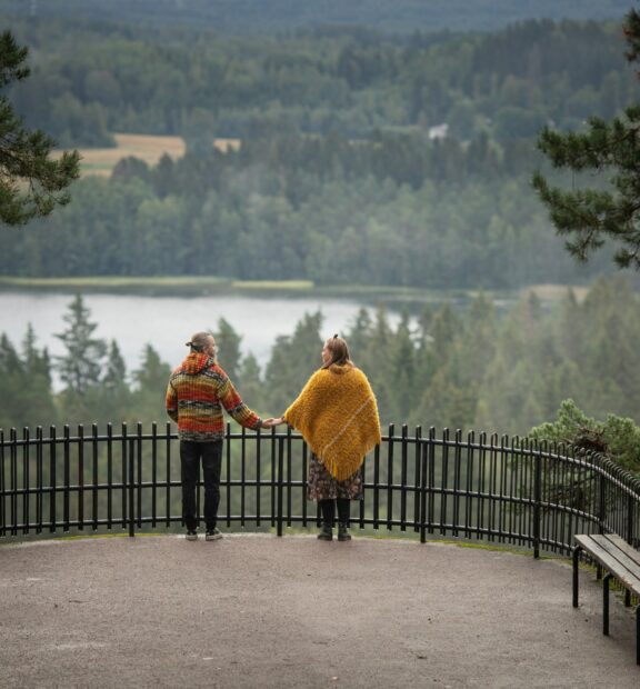 Pariskunta seisoo käsi kädessä Aulangon näköalatasanteella.